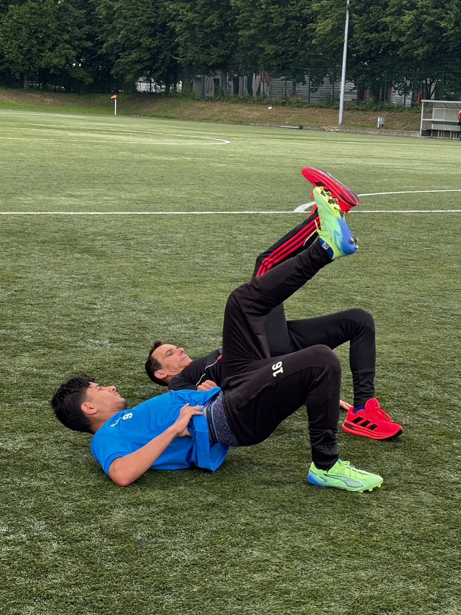 Ich beim Athletiktraining mit einem Fußballspieler auf dem Platz